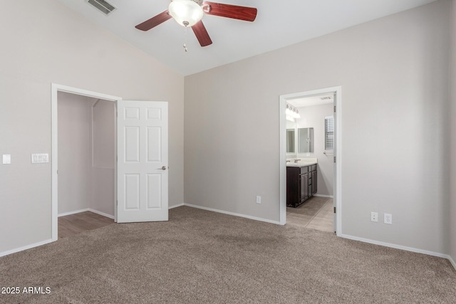 unfurnished bedroom featuring light colored carpet, lofted ceiling, visible vents, and baseboards
