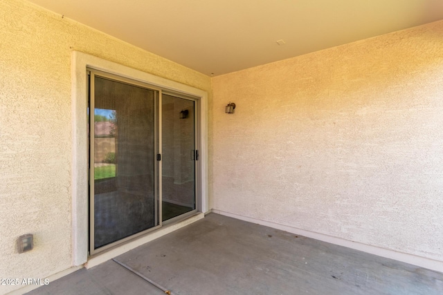 entrance to property with a patio and stucco siding