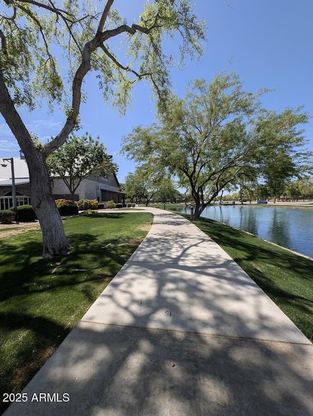 surrounding community with a lawn and a water view