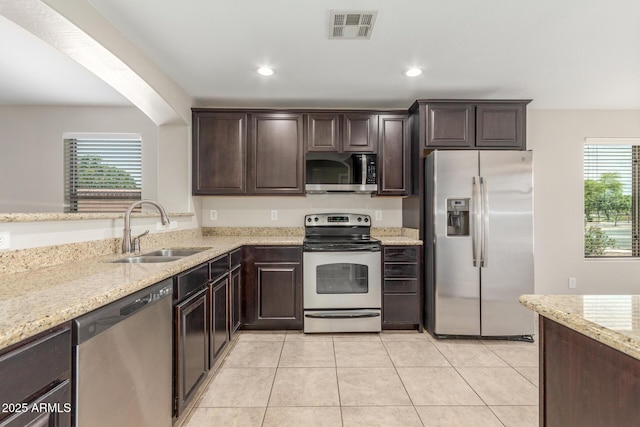 kitchen featuring visible vents, dark brown cabinetry, stainless steel appliances, and a sink