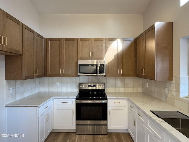 kitchen with backsplash, appliances with stainless steel finishes, dark hardwood / wood-style flooring, and white cabinets