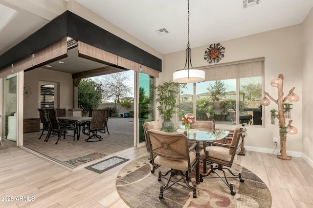 dining room with visible vents, baseboards, and wood finished floors