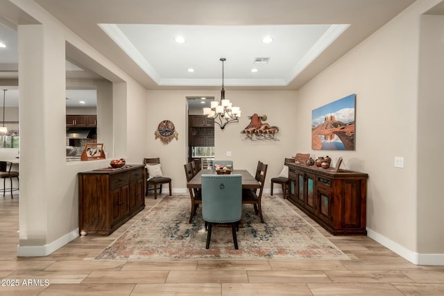 dining room with a chandelier, wood finish floors, visible vents, and ornamental molding