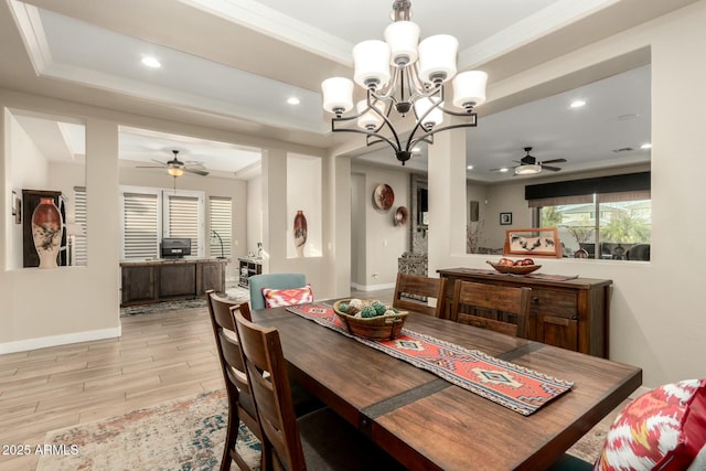 dining space featuring recessed lighting, baseboards, ornamental molding, a tray ceiling, and light wood finished floors