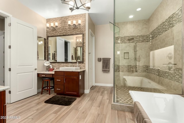 bathroom with a freestanding bath, a stall shower, wood finished floors, and vanity