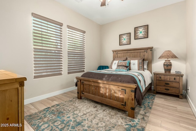 bedroom featuring baseboards, ceiling fan, and light wood-style floors