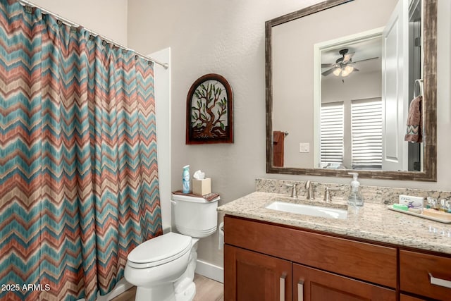 bathroom with toilet, curtained shower, a ceiling fan, and vanity