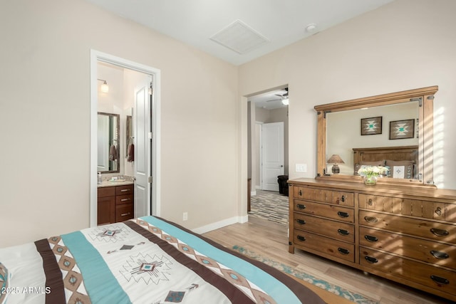 bedroom with light wood-type flooring, connected bathroom, and baseboards