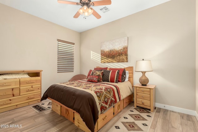 bedroom with baseboards, visible vents, ceiling fan, and wood finished floors