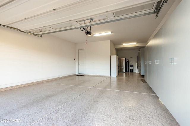 garage with a garage door opener and freestanding refrigerator