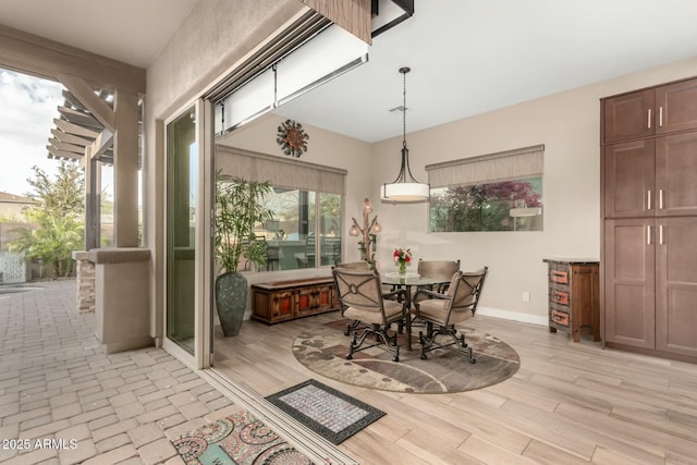 dining area with light wood-style floors and baseboards