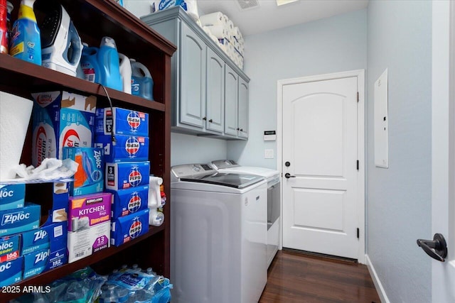 laundry area featuring dark hardwood / wood-style flooring, washer and dryer, and cabinets