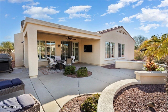 rear view of house with ceiling fan and a patio