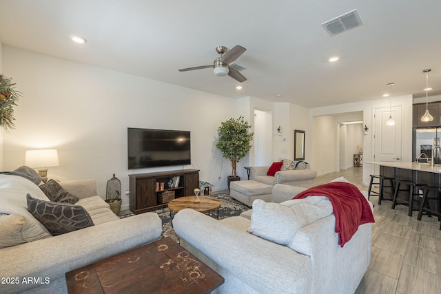 living area with ceiling fan, visible vents, and recessed lighting