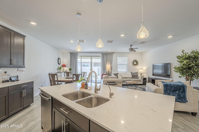 kitchen featuring hanging light fixtures, a sink, visible vents, and dark brown cabinetry