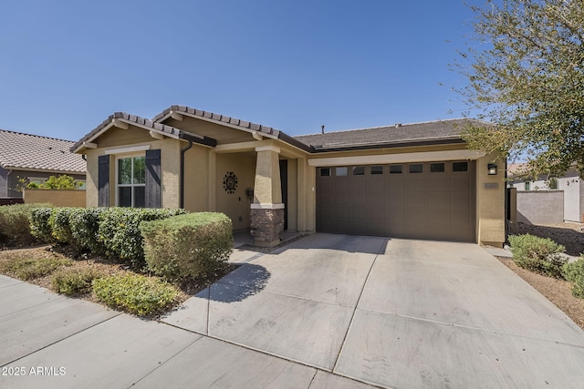 view of front facade featuring a garage, a tiled roof, concrete driveway, and stucco siding