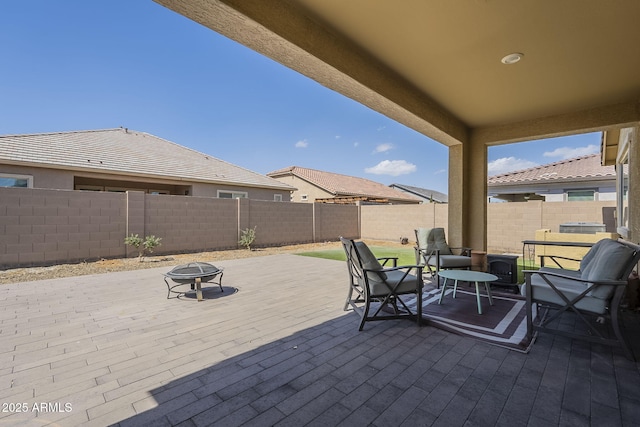 view of patio / terrace featuring an outdoor fire pit and a fenced backyard