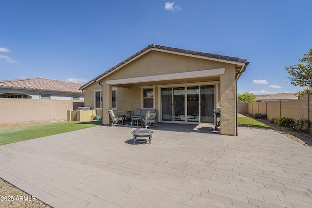 back of property featuring a patio area, a fenced backyard, a fire pit, and stucco siding