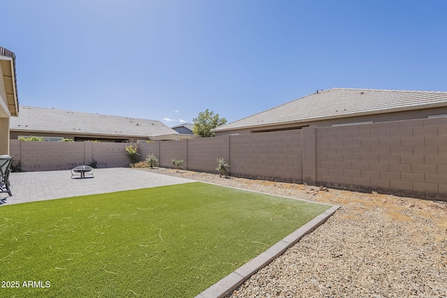 view of yard with a fire pit, a patio area, and a fenced backyard