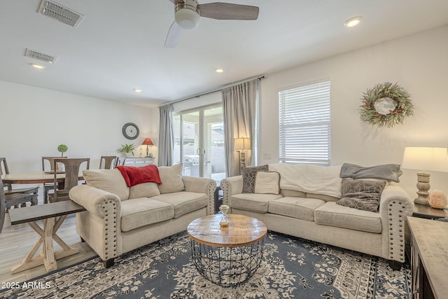 living room with light wood-style flooring, visible vents, ceiling fan, and recessed lighting