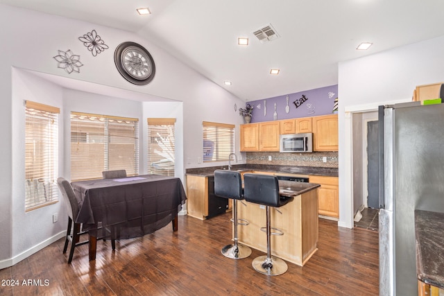 kitchen featuring dark hardwood / wood-style flooring, a center island, lofted ceiling, and appliances with stainless steel finishes