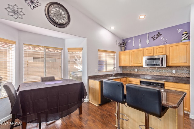 kitchen with backsplash, sink, black appliances, a center island, and dark hardwood / wood-style floors