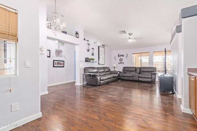 living room with ceiling fan with notable chandelier and dark hardwood / wood-style flooring