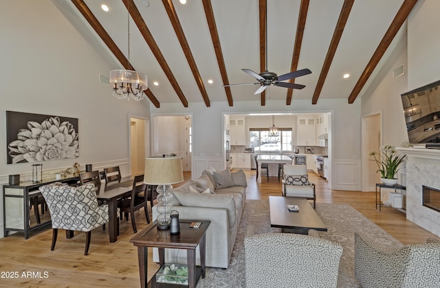 3813 N 37th St, Phoenix, AZ 85018 - living room with a chandelier, a decorative wall, ceiling fan, beam ceiling, and a high end fireplace