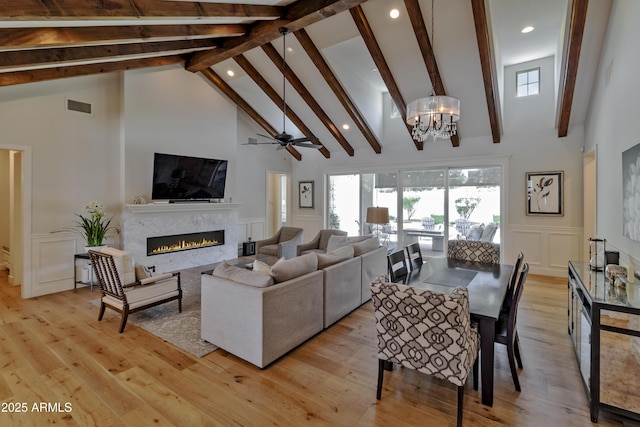 3813 N 37th St, Phoenix, AZ 85018 - living area featuring a decorative wall, high vaulted ceiling, beam ceiling, recessed lighting, and a warm lit fireplace