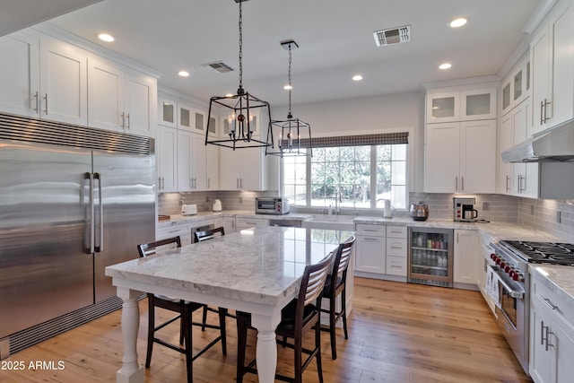3813 N 37th St, Phoenix, AZ 85018 - kitchen with high quality appliances, beverage cooler, under cabinet range hood, decorative backsplash, and recessed lighting