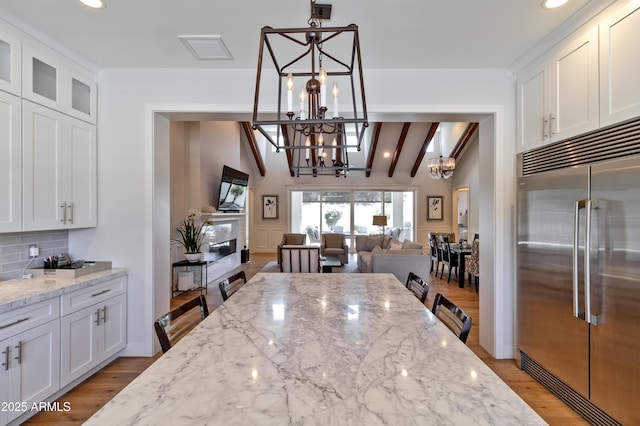 3813 N 37th St, Phoenix, AZ 85018 - kitchen with built in refrigerator, a chandelier, backsplash, white cabinetry, and recessed lighting