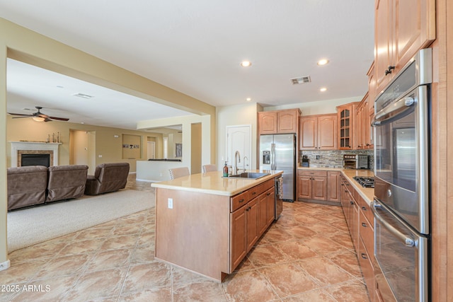 2514 E Grand Canyon Dr, Chandler, AZ 85249 - kitchen featuring stainless steel appliances, light countertops, tasteful backsplash, glass insert cabinets, and ceiling fan