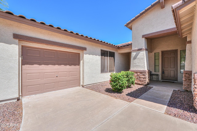 2514 E Grand Canyon Dr, Chandler, AZ 85249 - doorway to property featuring stucco siding, a garage, driveway, a tiled roof, and stone siding