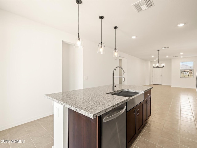 kitchen with light tile patterned flooring, pendant lighting, dishwasher, and a kitchen island with sink