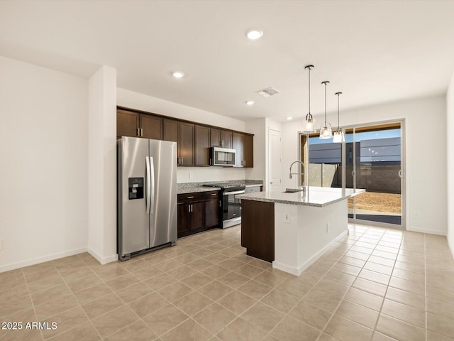 kitchen with a center island with sink, sink, dark brown cabinetry, hanging light fixtures, and appliances with stainless steel finishes