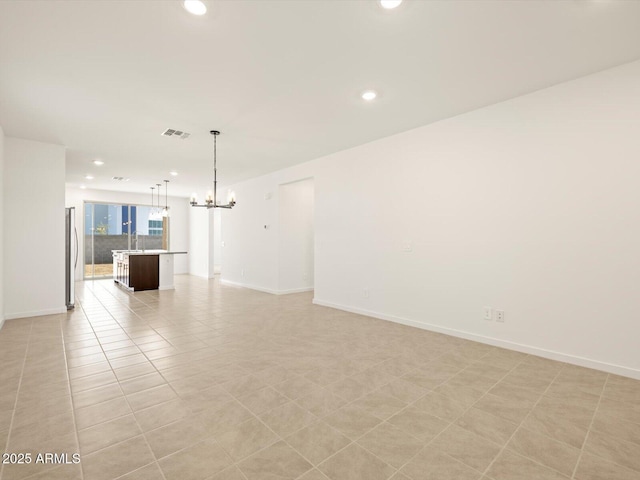 unfurnished room with light tile patterned flooring and an inviting chandelier