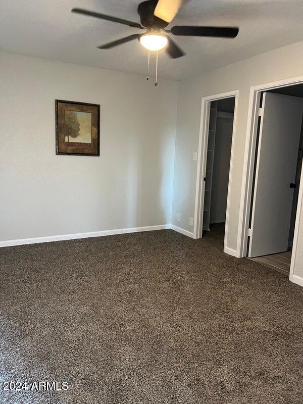 carpeted empty room featuring ceiling fan