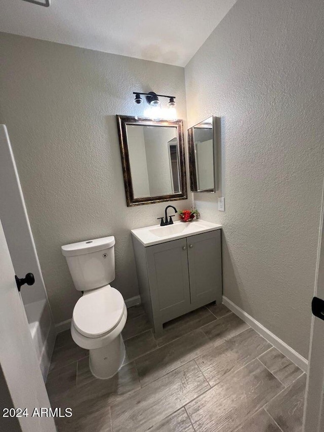 bathroom with vanity, toilet, and wood-type flooring