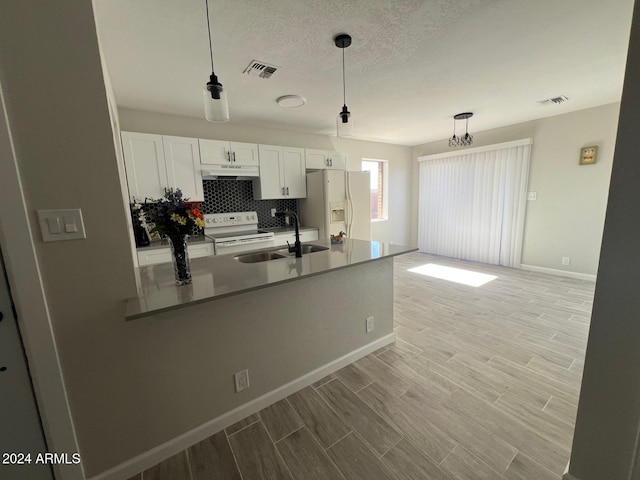 kitchen featuring white cabinetry, sink, pendant lighting, white appliances, and light hardwood / wood-style floors