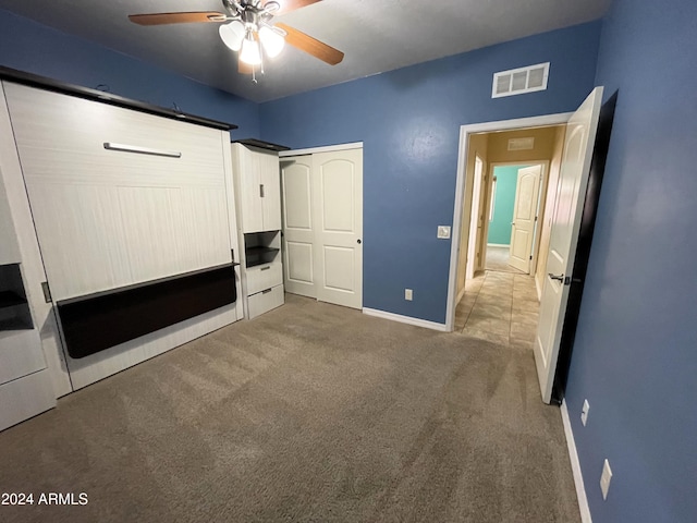 unfurnished bedroom featuring carpet floors, ceiling fan, and a closet