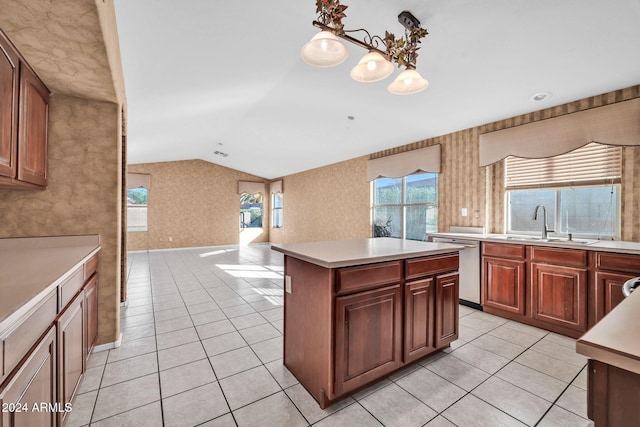 kitchen with lofted ceiling, dishwasher, hanging light fixtures, light tile patterned floors, and a kitchen island