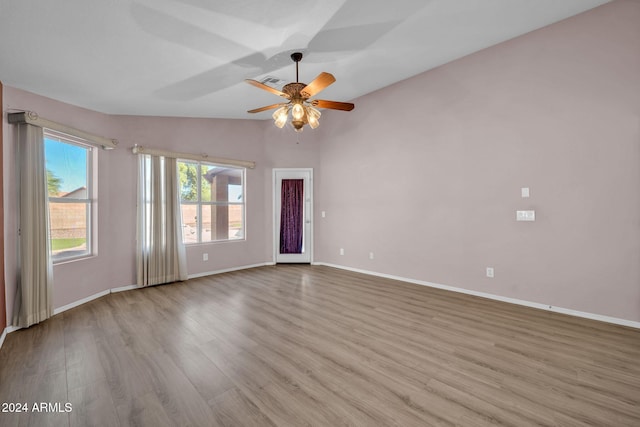 unfurnished room with lofted ceiling, ceiling fan, and light hardwood / wood-style flooring