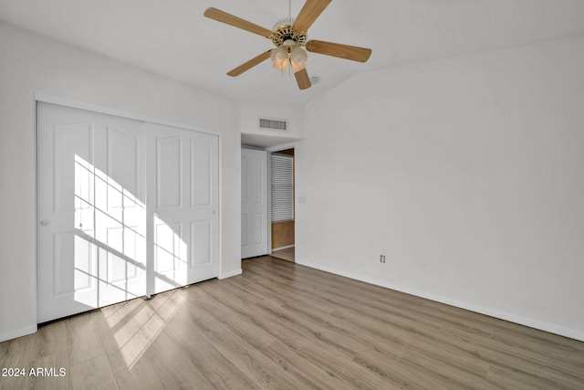 unfurnished bedroom with a closet, vaulted ceiling, ceiling fan, and light hardwood / wood-style flooring