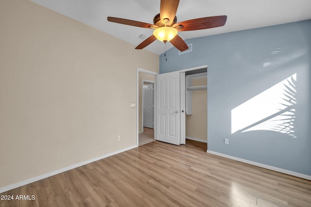 unfurnished bedroom featuring a closet, vaulted ceiling, ceiling fan, and light hardwood / wood-style flooring