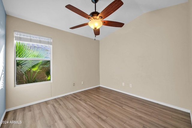 spare room featuring light wood-type flooring, lofted ceiling, and ceiling fan