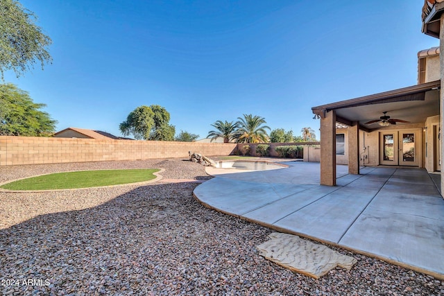 view of yard featuring french doors, ceiling fan, and a patio area