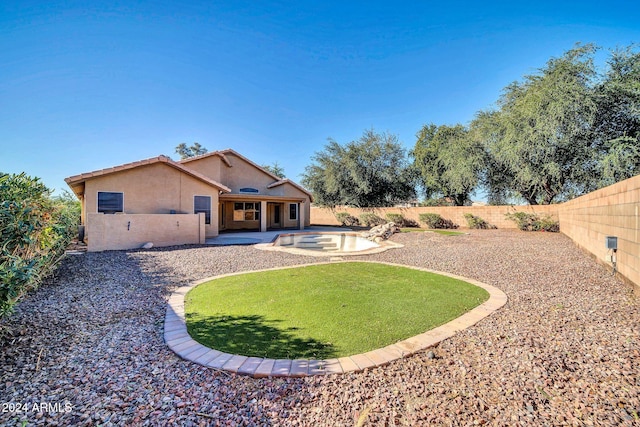 rear view of property with a lawn and a patio