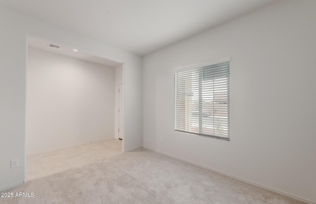 carpeted empty room with baseboards and visible vents