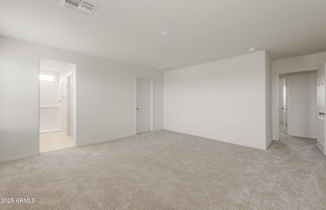 spare room featuring light carpet and visible vents