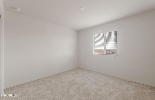 unfurnished room featuring carpet floors and baseboards